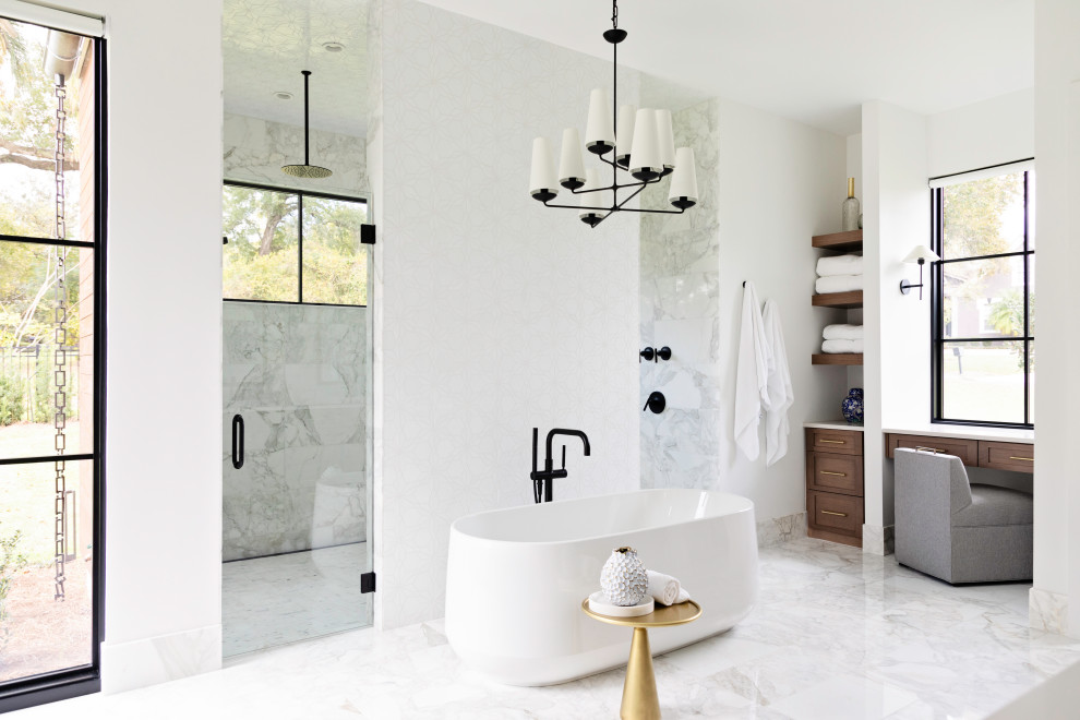 This is an example of an expansive transitional master bathroom in Orlando with shaker cabinets, a freestanding tub, a double shower, white tile, white walls, marble floors, white floor, a hinged shower door, white benchtops, a built-in vanity and medium wood cabinets.