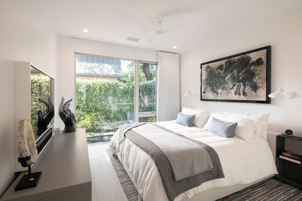 Inspiration for a mid-sized modern master bedroom in Austin with white walls, porcelain floors and grey floor.
