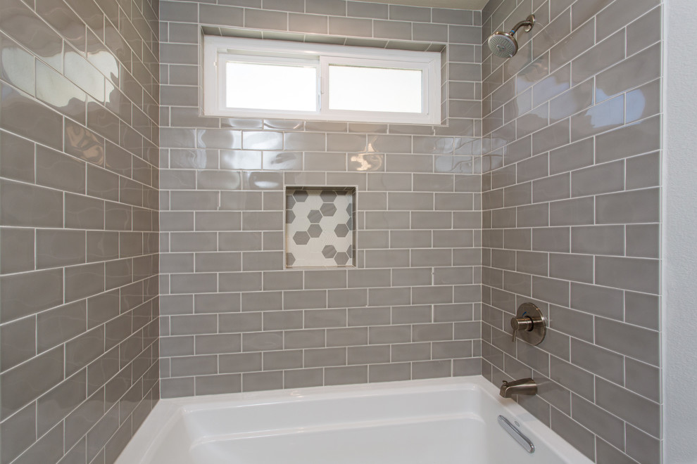 Photo of a small transitional kids bathroom in Los Angeles with raised-panel cabinets, grey cabinets, an alcove tub, a shower/bathtub combo, a one-piece toilet, gray tile, subway tile, grey walls, mosaic tile floors, an undermount sink, engineered quartz benchtops, grey floor and a shower curtain.