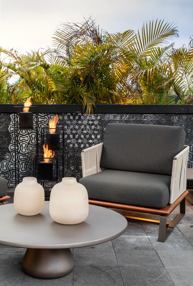 This is an example of a large industrial rooftop and rooftop deck in Miami with with fireplace and a pergola.