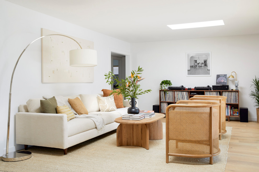 This is an example of a medium sized midcentury enclosed living room in San Francisco with a music area, white walls, light hardwood flooring, no fireplace, no tv and brown floors.