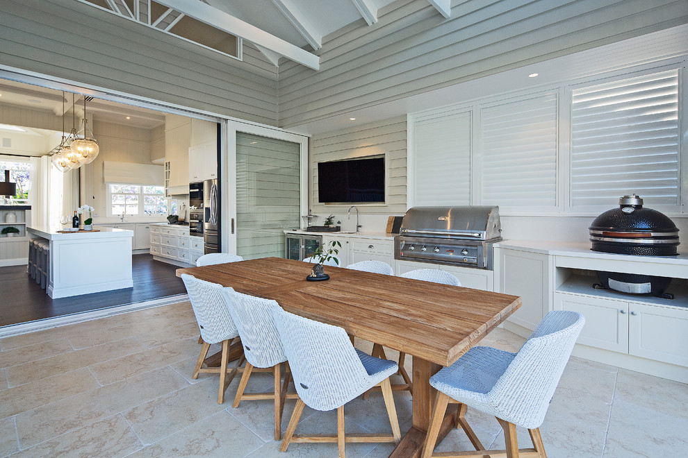 This is an example of a large beach style backyard deck in Brisbane with a roof extension.