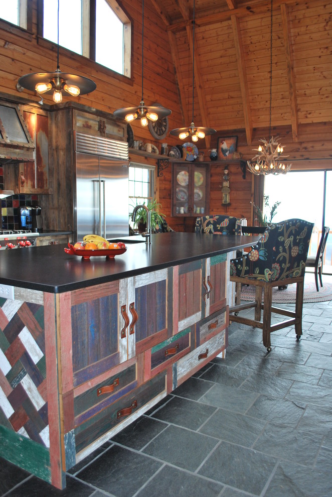 Large mountain style l-shaped slate floor eat-in kitchen photo in Richmond with shaker cabinets, distressed cabinets, soapstone countertops, an island, a single-bowl sink, multicolored backsplash, glass tile backsplash and stainless steel appliances
