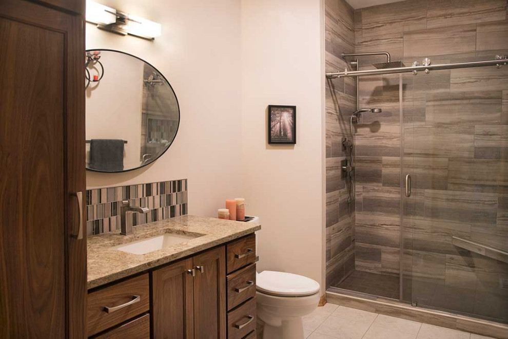 Photo of a mid-sized transitional 3/4 bathroom in Other with shaker cabinets, medium wood cabinets, an alcove shower, a two-piece toilet, beige tile, ceramic tile, beige walls, ceramic floors, an undermount sink, engineered quartz benchtops, beige floor, a sliding shower screen, beige benchtops, a shower seat, a single vanity and a built-in vanity.