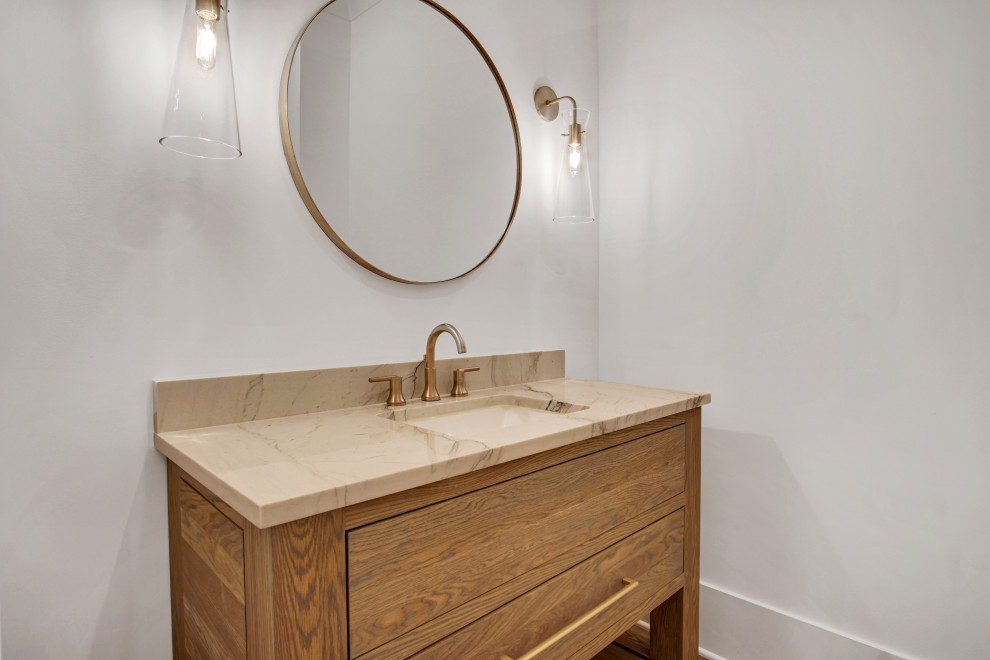 Design ideas for a large transitional powder room in Atlanta with flat-panel cabinets, medium wood cabinets, a two-piece toilet, white walls, medium hardwood floors, an undermount sink, engineered quartz benchtops, grey floor, white benchtops and a freestanding vanity.