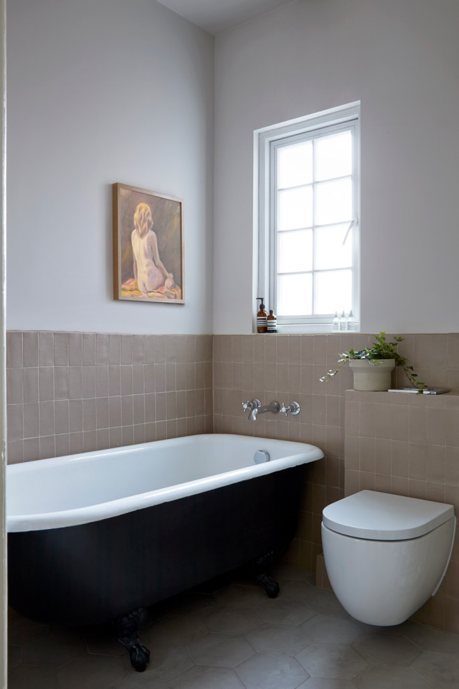 Стильный дизайн: ванная комната в современном стиле с ванной на ножках и розовой плиткой - последний тренд