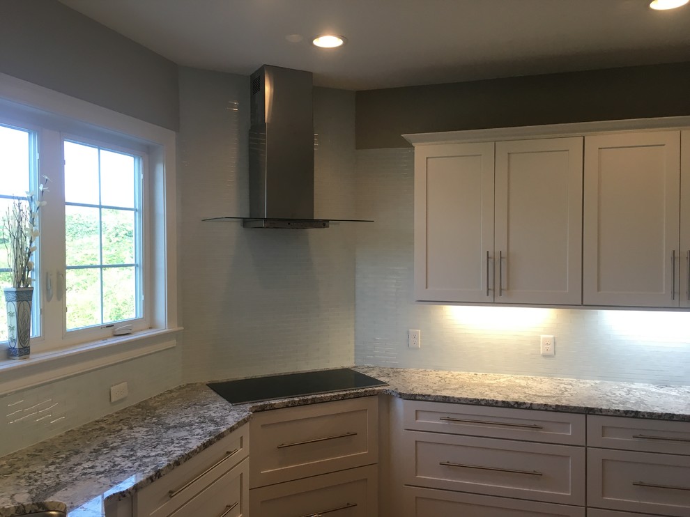Enclosed kitchen - mid-sized transitional l-shaped enclosed kitchen idea in Boston with an undermount sink, stainless steel appliances, shaker cabinets, white cabinets, granite countertops, multicolored countertops, gray backsplash and glass tile backsplash