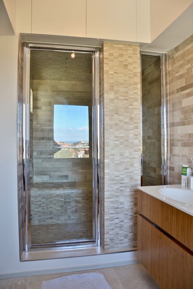 This is an example of a mid-sized contemporary bathroom in Rome with flat-panel cabinets, light wood cabinets, an open shower, a two-piece toilet, white tile, ceramic tile, white walls, porcelain floors, with a sauna, a drop-in sink, solid surface benchtops, beige floor and a hinged shower door.