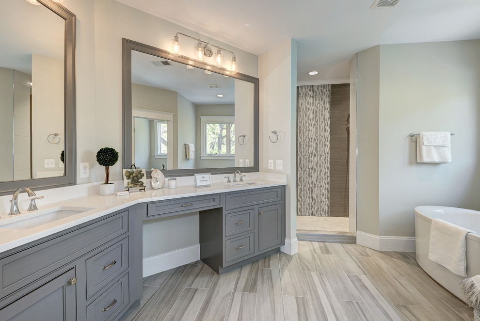 This is an example of an expansive modern master bathroom in DC Metro with raised-panel cabinets, dark wood cabinets, an alcove shower, a one-piece toilet, grey walls, light hardwood floors, a drop-in sink, granite benchtops and a freestanding tub.