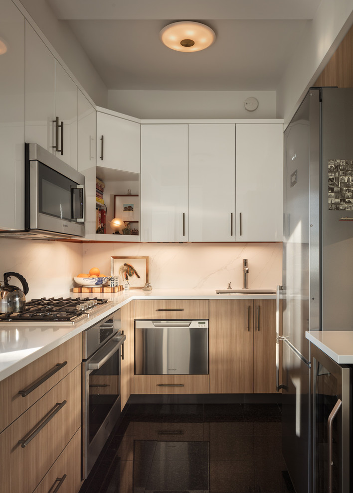 Small transitional u-shaped eat-in kitchen in New York with an undermount sink, flat-panel cabinets, light wood cabinets, quartz benchtops, white splashback, marble splashback, stainless steel appliances, ceramic floors, no island, black floor and grey benchtop.