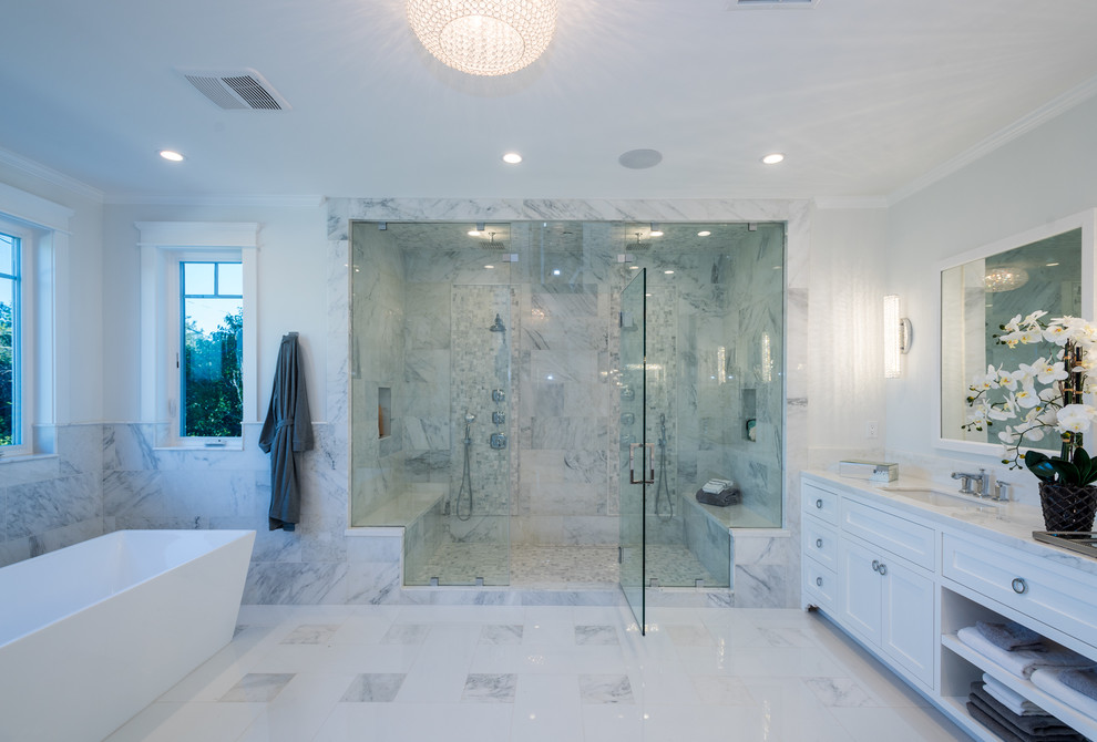 Inspiration for a large traditional master bathroom in Los Angeles with beaded inset cabinets, white cabinets, a freestanding tub, a double shower, white tile, marble, white walls, marble floors, an undermount sink, marble benchtops, white floor and a hinged shower door.