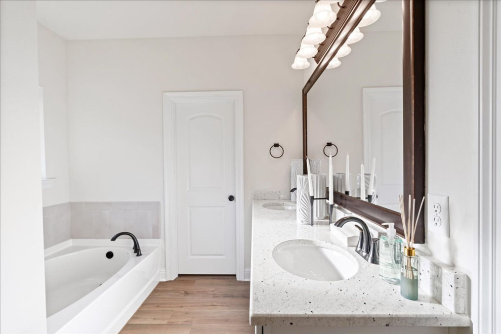 Mid-sized traditional master bathroom in Other with white cabinets, white walls, light hardwood floors, a drop-in sink, granite benchtops, brown floor, white benchtops, a double vanity and a built-in vanity.