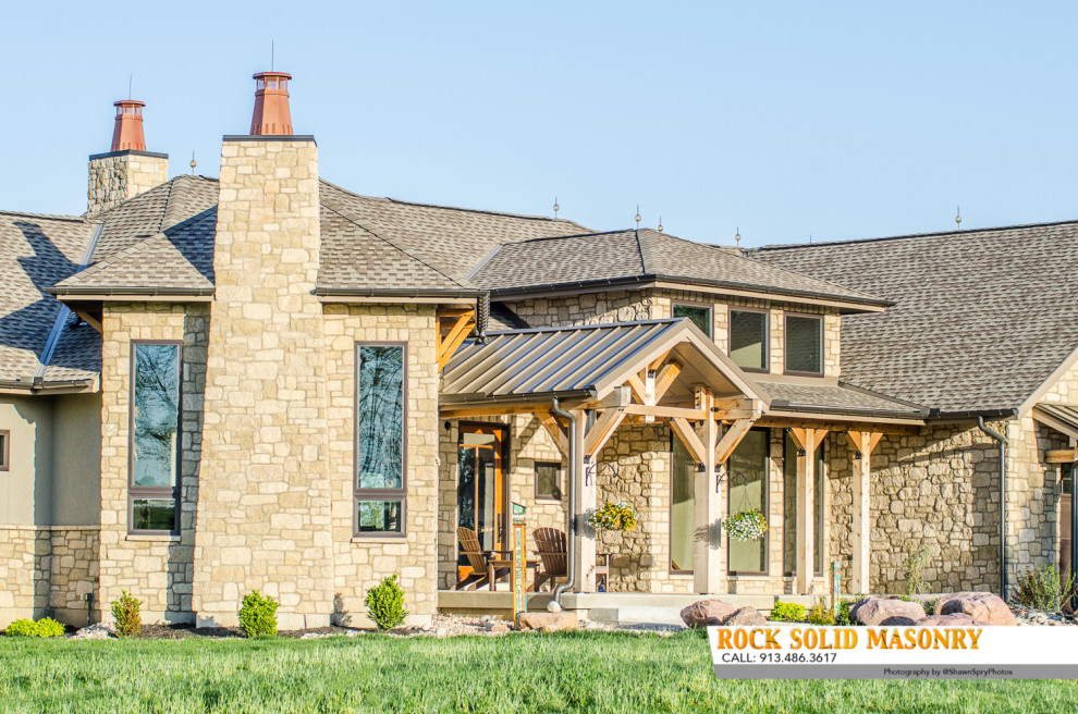 Design ideas for a country beige house exterior in Kansas City with stone veneer.