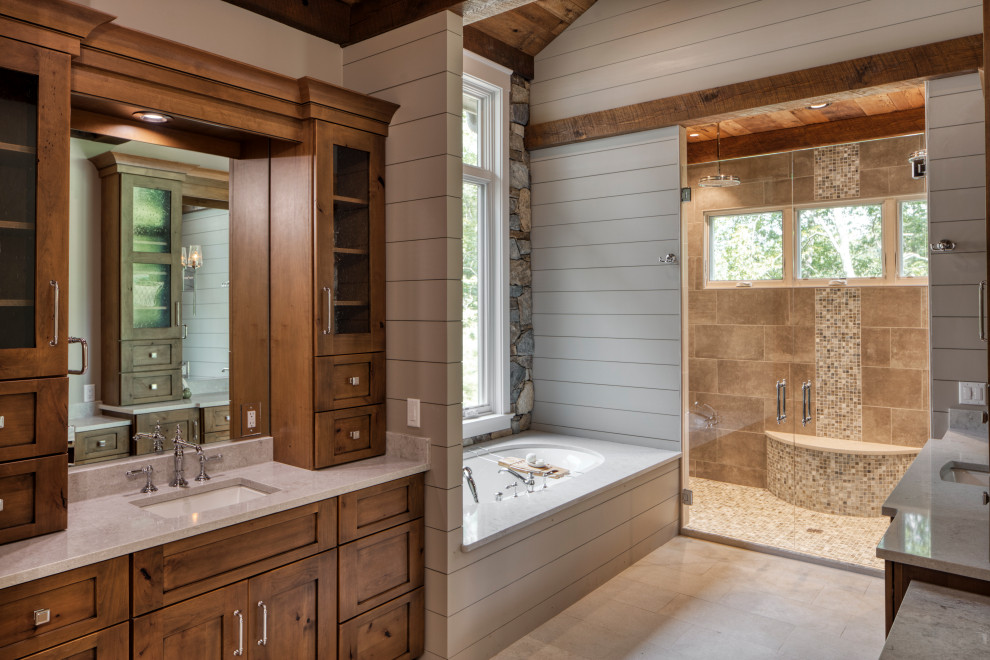 This is an example of a large traditional master wet room bathroom in Charlotte with shaker cabinets, brown cabinets, an undermount tub, a two-piece toilet, beige tile, ceramic tile, grey walls, ceramic floors, an undermount sink, engineered quartz benchtops, grey floor, a hinged shower door, beige benchtops, a shower seat, a single vanity, a built-in vanity, coffered and wood walls.