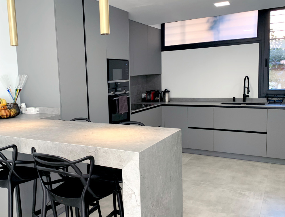 Idéer för ett stort modernt grå kök, med luckor med infälld panel, grå skåp, bänkskiva i betong, svarta vitvaror, klinkergolv i porslin och grått golv