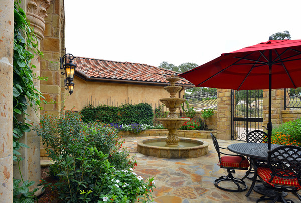This is an example of a large mediterranean one-storey stucco brown exterior in Austin with a hip roof.