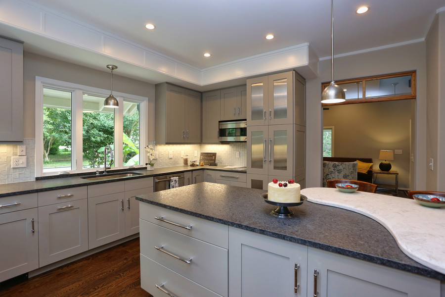 Photo of a small modern kitchen in Raleigh with an undermount sink, recessed-panel cabinets, white cabinets, granite benchtops, white splashback, ceramic splashback, stainless steel appliances, medium hardwood floors and with island.