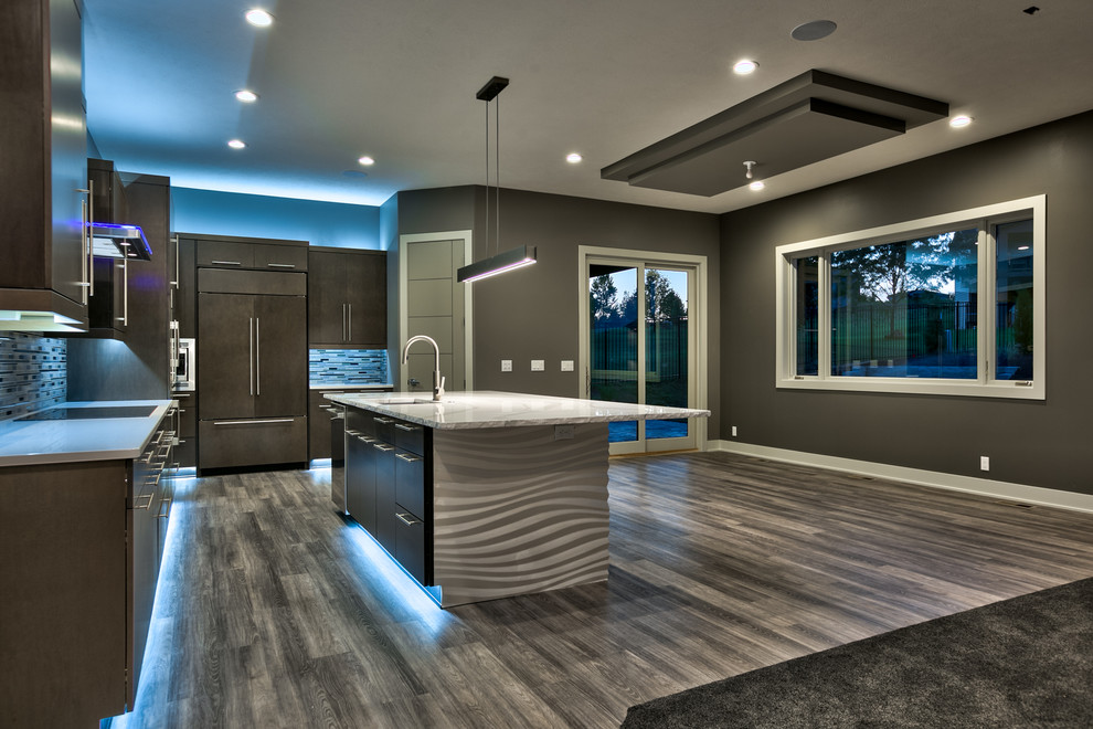 Photo of a large modern galley eat-in kitchen in Omaha with an undermount sink, flat-panel cabinets, dark wood cabinets, quartzite benchtops, metallic splashback, metal splashback, stainless steel appliances, vinyl floors and with island.