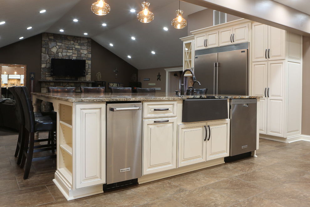 Inspiration for a large transitional u-shaped porcelain tile and brown floor open concept kitchen remodel with a farmhouse sink, raised-panel cabinets, white cabinets, granite countertops, beige backsplash, travertine backsplash, stainless steel appliances and an island