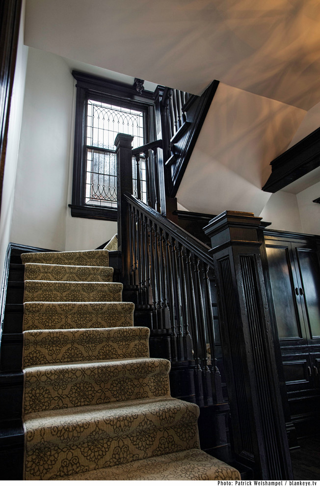 This is an example of a mid-sized traditional carpeted u-shaped staircase in Portland with wood risers.