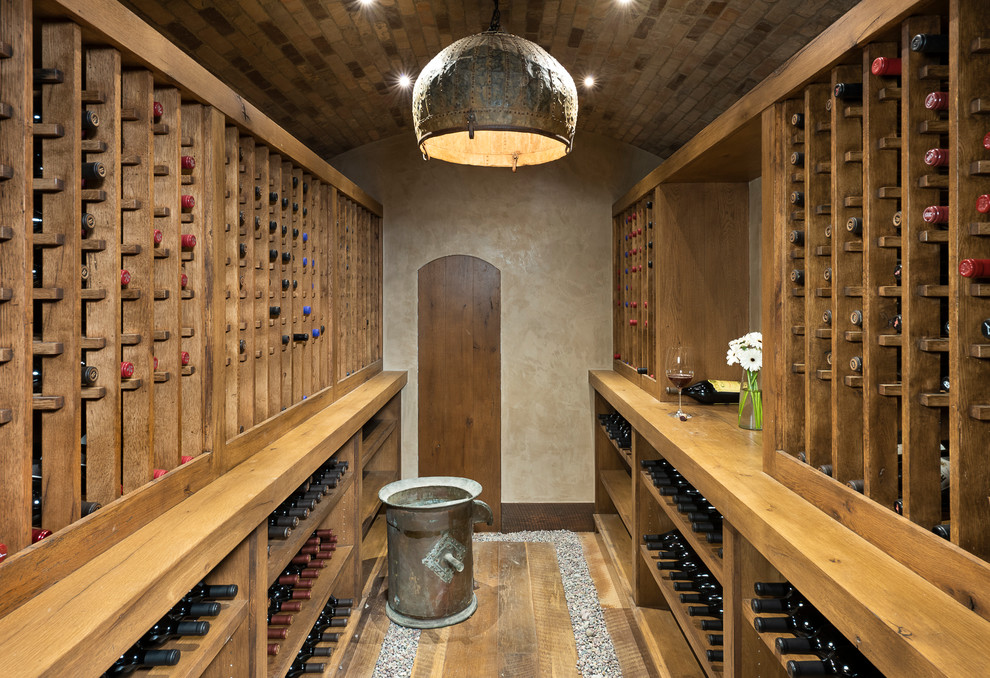Small mountain style medium tone wood floor wine cellar photo in Other