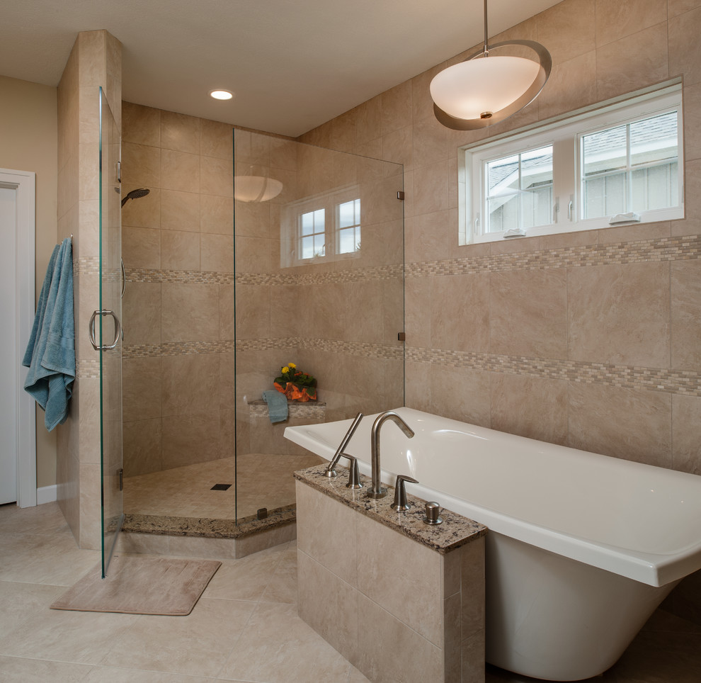 Large transitional master beige tile and stone tile porcelain tile freestanding bathtub photo with an undermount sink, recessed-panel cabinets, medium tone wood cabinets, granite countertops and beige walls