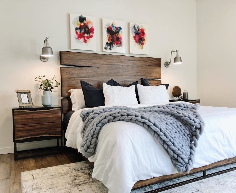 Inspiration for a mid-sized industrial master bedroom in Portland with white walls, medium hardwood floors and brown floor.