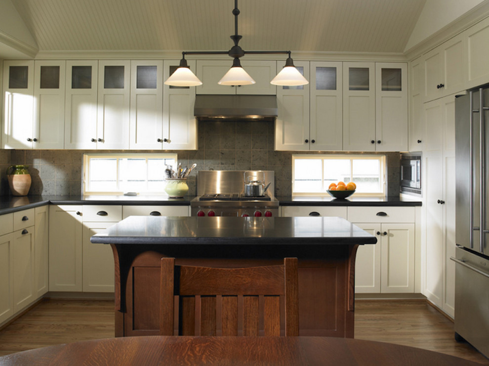 Inspiration for a mid-sized transitional u-shaped medium tone wood floor and brown floor open concept kitchen remodel in Toronto with shaker cabinets, white cabinets, solid surface countertops, gray backsplash, ceramic backsplash, stainless steel appliances and an island