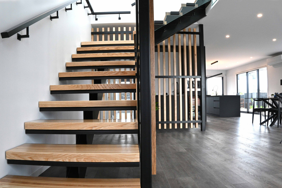 Diseño de escalera suspendida grande con escalones de madera y barandilla de vidrio