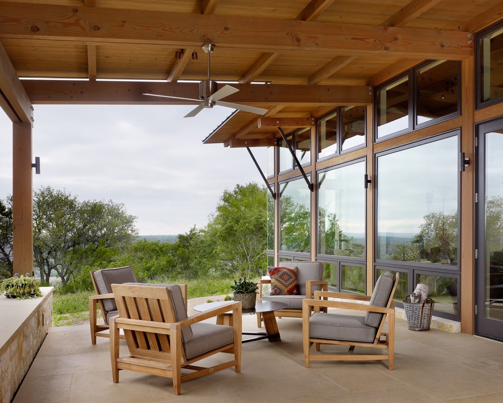 This is an example of a mid-sized backyard patio in Austin with a roof extension.