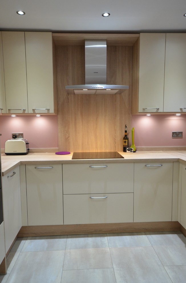 Photo of a mid-sized contemporary u-shaped eat-in kitchen in Other with laminate benchtops, terra-cotta floors, no island, a double-bowl sink, shaker cabinets, medium wood cabinets, brown splashback, timber splashback, coloured appliances and white floor.
