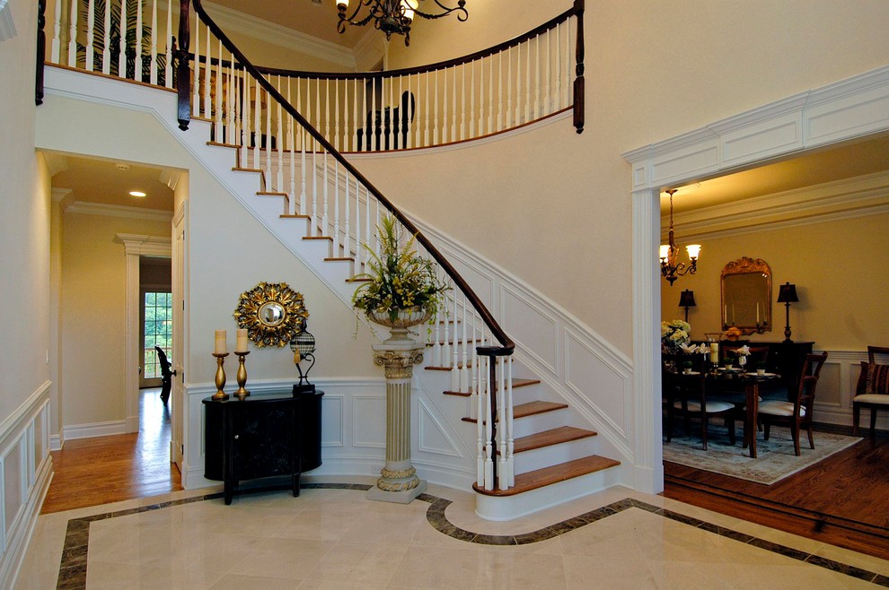 This is an example of a large traditional wood curved staircase in New York with painted wood risers and wood railing.