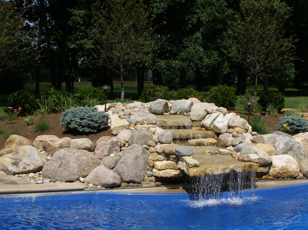 Pool - rustic backyard stone aboveground pool idea in Cincinnati
