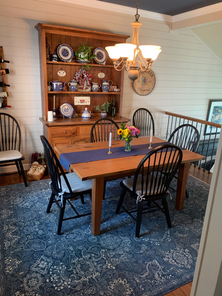 Immagine di una sala da pranzo country chiusa e di medie dimensioni con pareti bianche, pavimento in legno massello medio, soffitto ribassato e pareti in perlinato