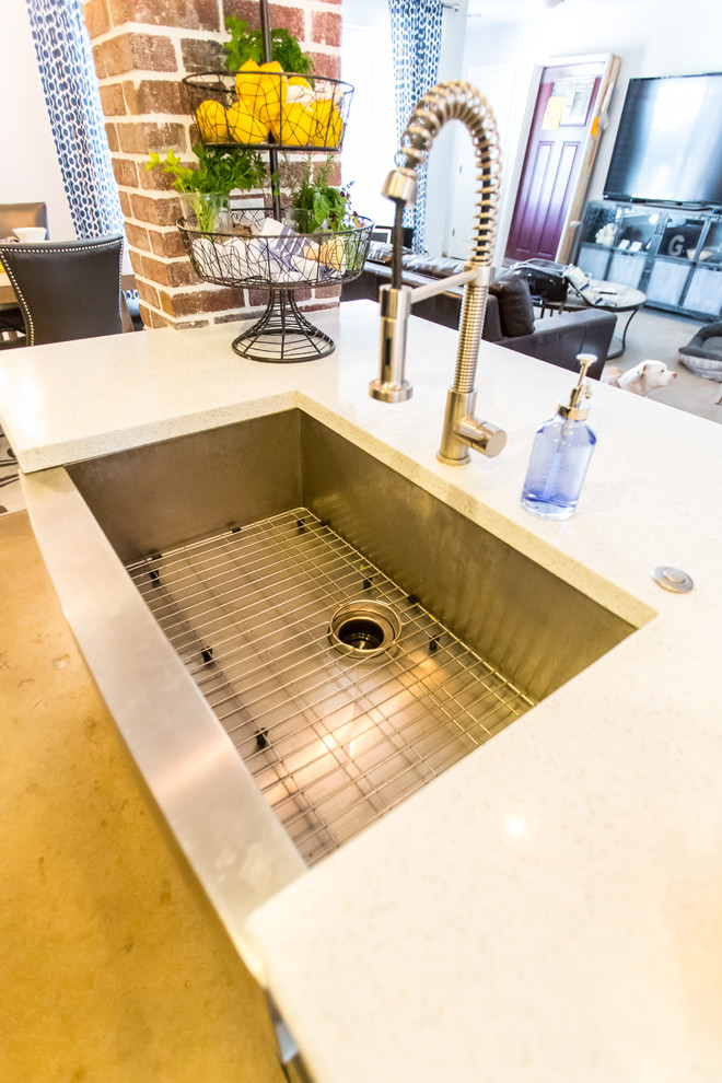 Example of a mid-sized mountain style single-wall concrete floor and gray floor open concept kitchen design in Phoenix with dark wood cabinets, blue backsplash, stainless steel appliances, an island, an undermount sink, shaker cabinets, quartzite countertops and glass tile backsplash