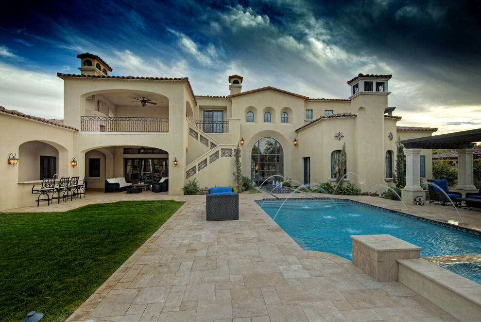 Expansive traditional backyard rectangular lap pool in Phoenix with natural stone pavers and a water feature.