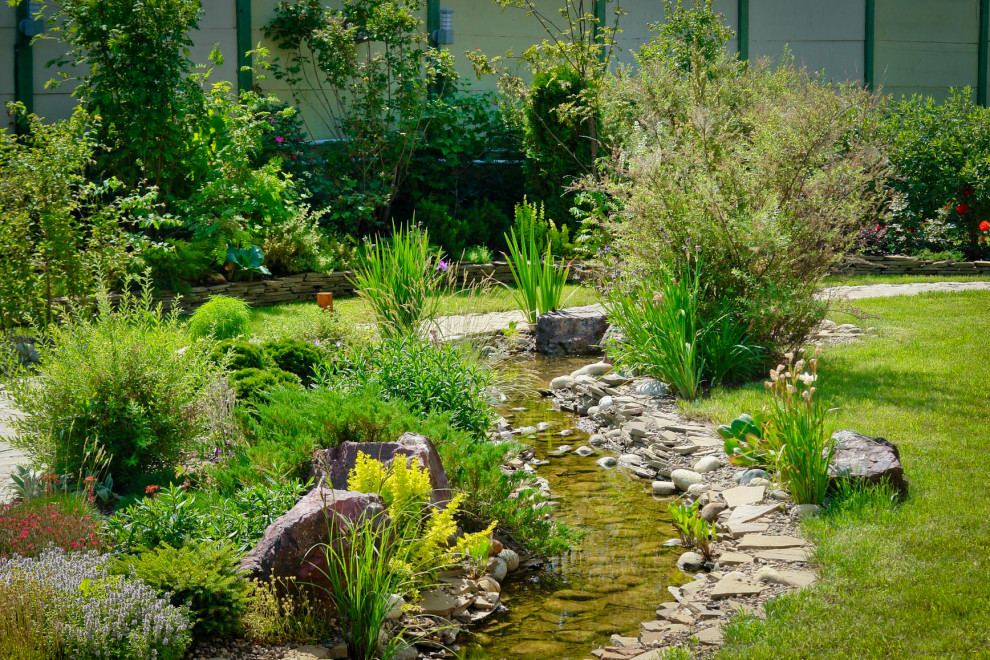 Идея дизайна: солнечный, летний участок и сад среднего размера на заднем дворе в современном стиле с камнем в ландшафтном дизайне, хорошей освещенностью и покрытием из гравия