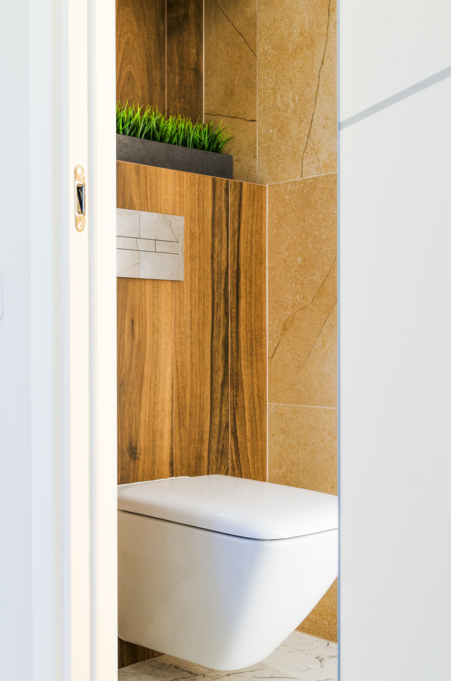 Photo of a small contemporary powder room in Other with a wall-mount toilet, beige tile, porcelain tile, porcelain floors and beige floor.