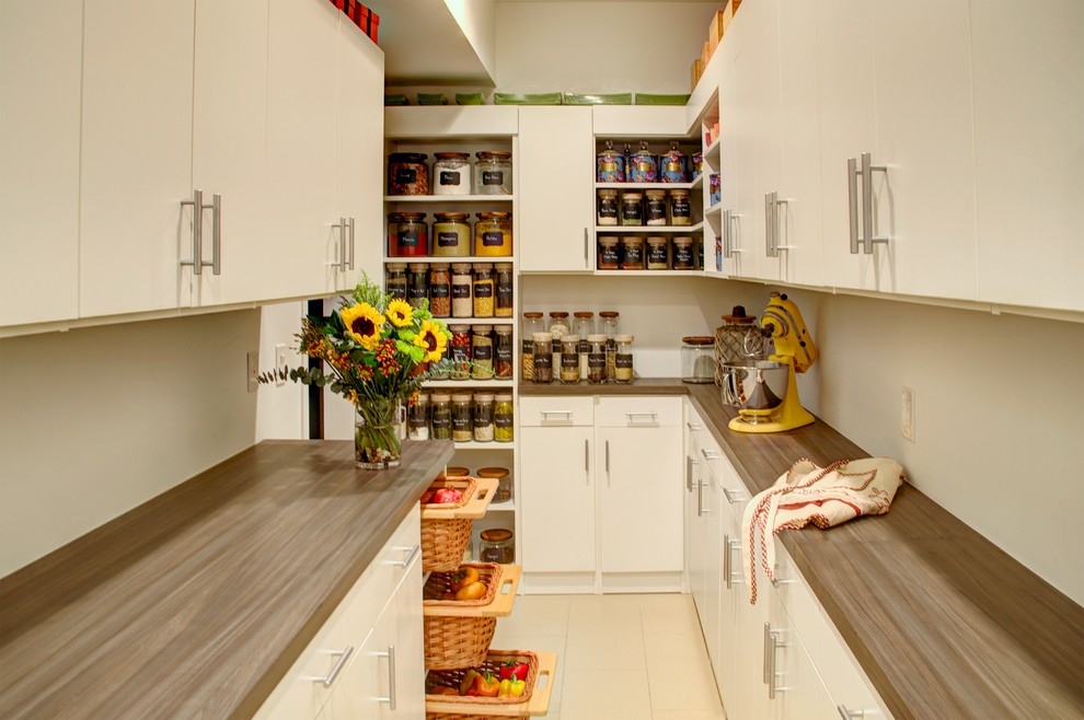 Inspiration for a large country u-shaped kitchen pantry in Philadelphia with flat-panel cabinets, white cabinets, laminate benchtops, porcelain floors and beige floor.