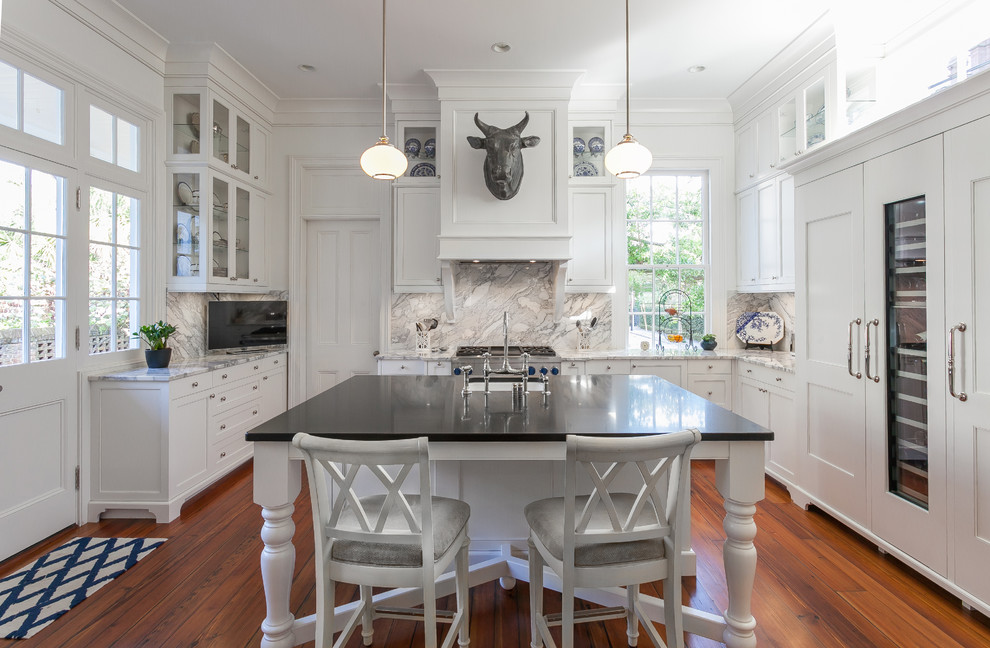 Photo of a traditional u-shaped kitchen in Charleston with an undermount sink, shaker cabinets, white cabinets, white splashback, panelled appliances, dark hardwood floors and with island.