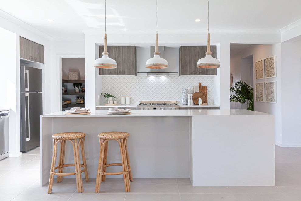 This is an example of a mid-sized tropical galley open plan kitchen in Melbourne with an undermount sink, quartz benchtops, white splashback, ceramic splashback, stainless steel appliances, ceramic floors, with island, beige floor and yellow benchtop.
