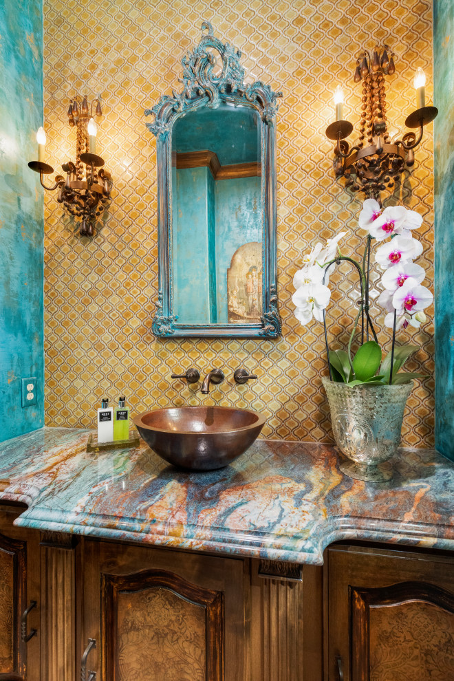 Пример оригинального дизайна: туалет среднего размера в стиле фьюжн с фасадами с выступающей филенкой, коричневыми фасадами, раздельным унитазом, желтой плиткой, керамогранитной плиткой, синими стенами, полом из травертина, настольной раковиной, столешницей из гранита, бежевым полом, разноцветной столешницей и встроенной тумбой