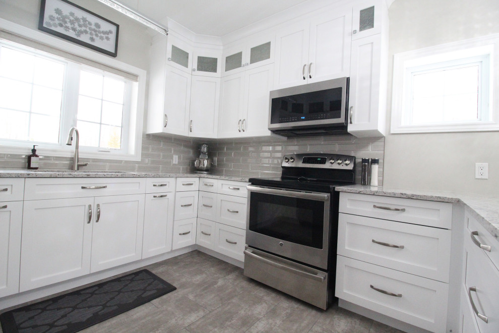 Kitchen - u-shaped kitchen idea with shaker cabinets, white cabinets, quartzite countertops, gray backsplash, subway tile backsplash, a peninsula and gray countertops