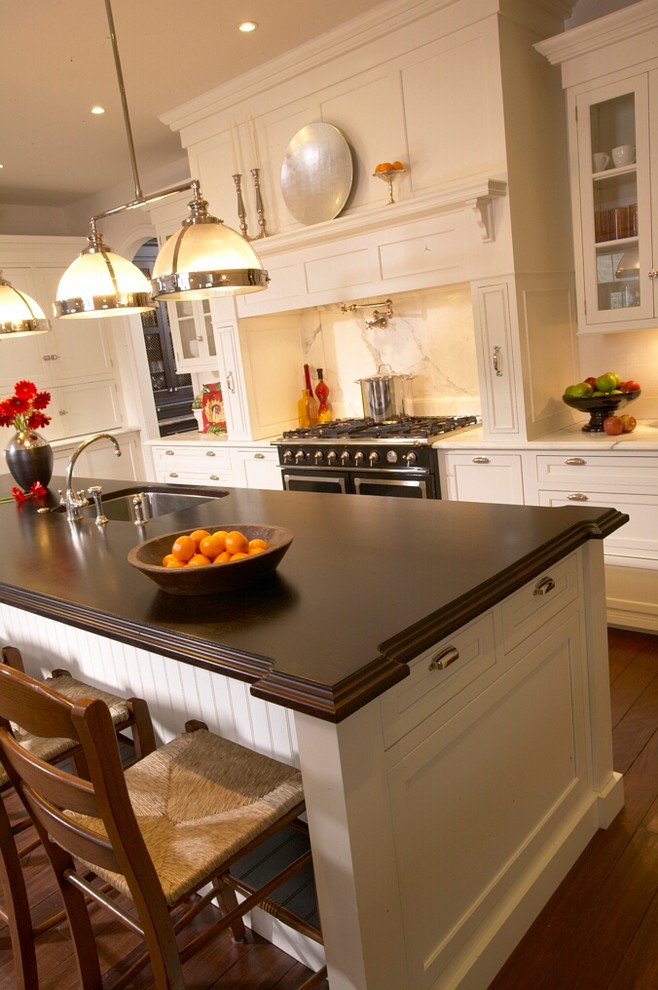 Inspiration for a transitional dark wood floor kitchen remodel in Chicago with an undermount sink, shaker cabinets, white cabinets, marble countertops, white backsplash, paneled appliances and an island