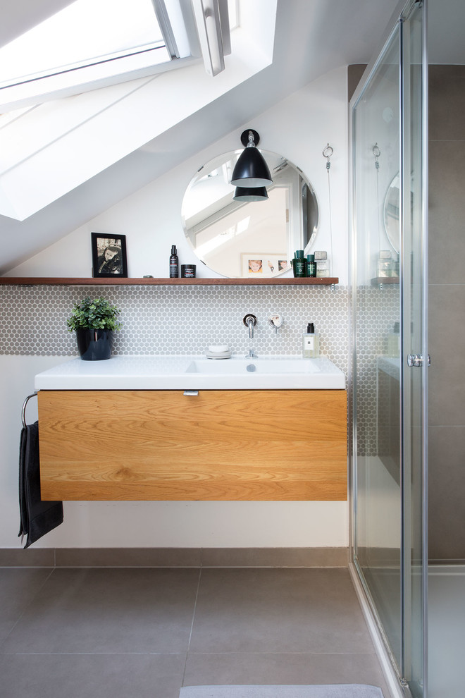 Contemporary 3/4 bathroom in London with flat-panel cabinets, medium wood cabinets, beige tile, multi-coloured walls, an integrated sink and beige floor.