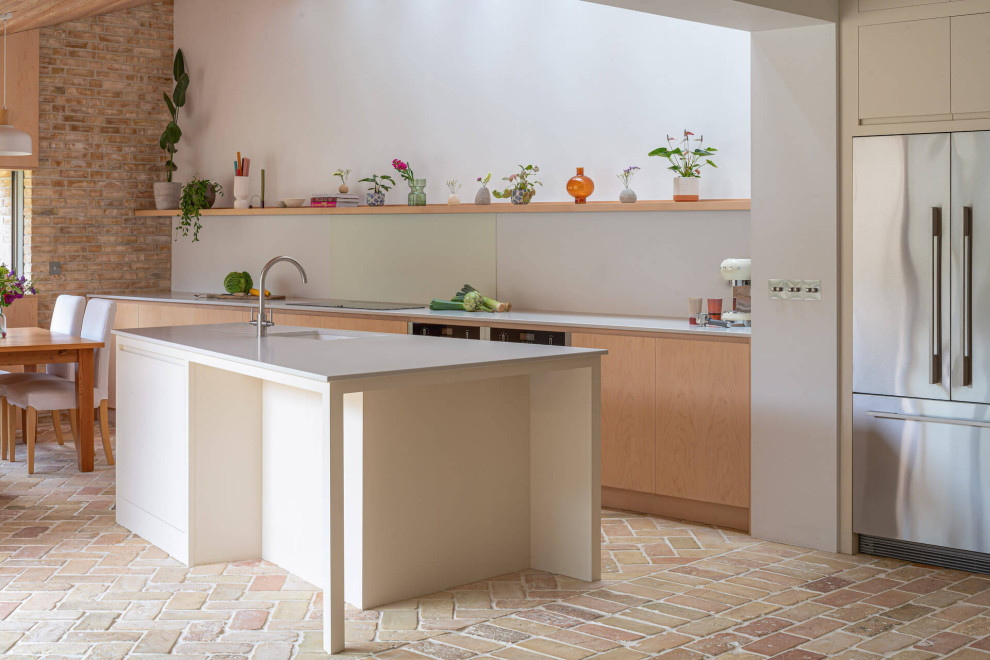 Immagine di una grande cucina scandinava con ante lisce, ante in legno chiaro, top in superficie solida, pavimento in mattoni e top grigio