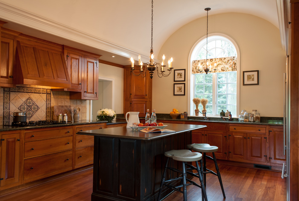 Large cottage u-shaped medium tone wood floor eat-in kitchen photo in Philadelphia with an undermount sink, raised-panel cabinets, medium tone wood cabinets, granite countertops, beige backsplash, stone tile backsplash, an island and stainless steel appliances