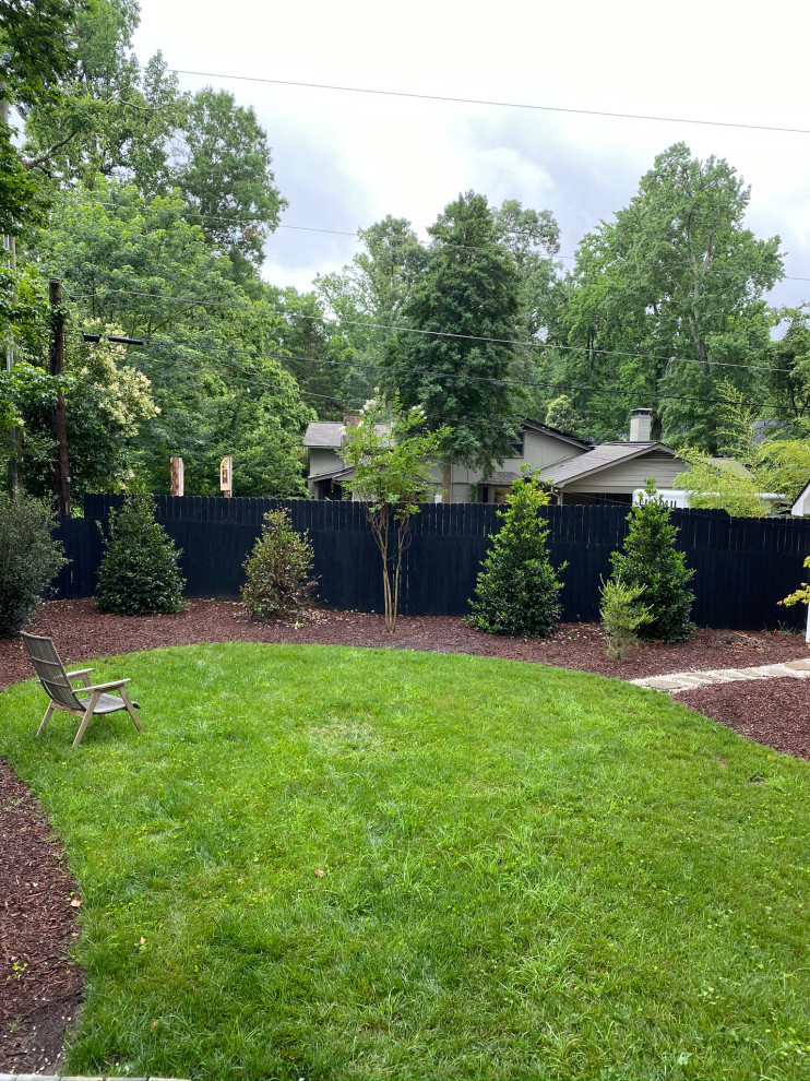 シャーロットにある高級な中くらいな、夏のミッドセンチュリースタイルのおしゃれな庭 (ファイヤーピット、半日向、天然石敷き、ウッドフェンス) の写真