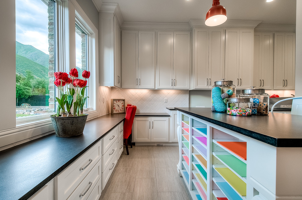 Design ideas for a mid-sized traditional l-shaped utility room in Salt Lake City with an undermount sink, shaker cabinets, white cabinets, granite benchtops, porcelain floors, a side-by-side washer and dryer and grey walls.