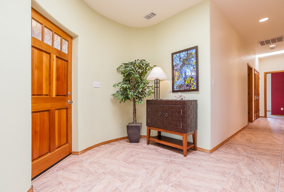 Design ideas for a mid-sized foyer in Albuquerque with green walls, porcelain floors, a single front door and a medium wood front door.